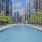 The pool area at The Alyx at Echelon Seaport in Boston, featuring lounge chairs, umbrellas, and a view of the apartments.